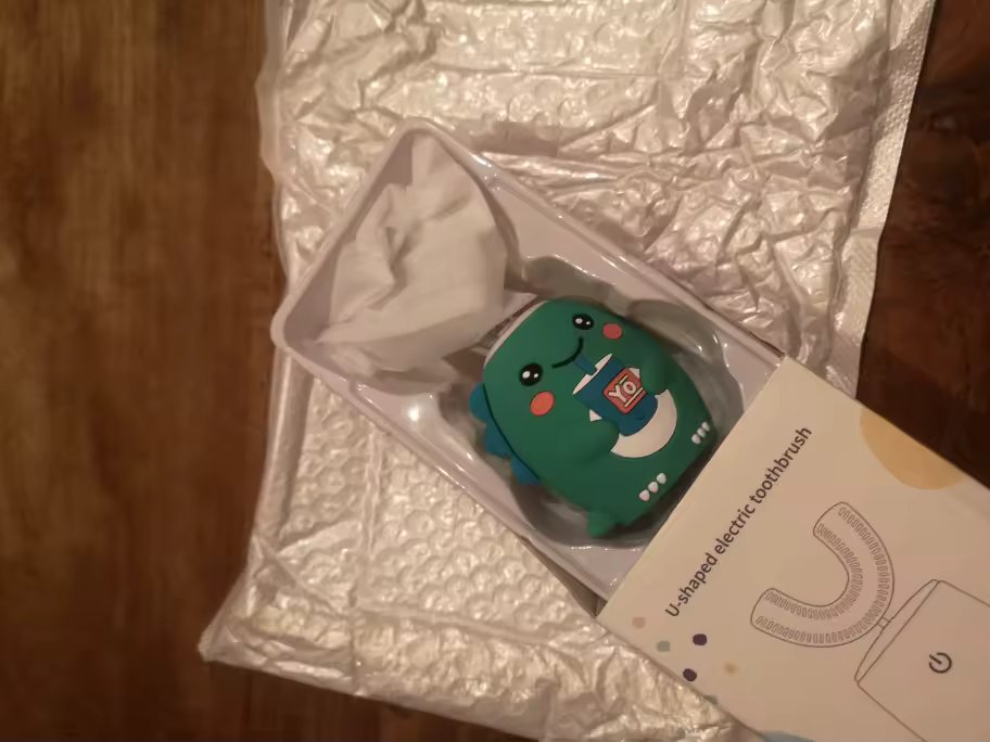 SnugBrush teal dinosaur handle in its opened box