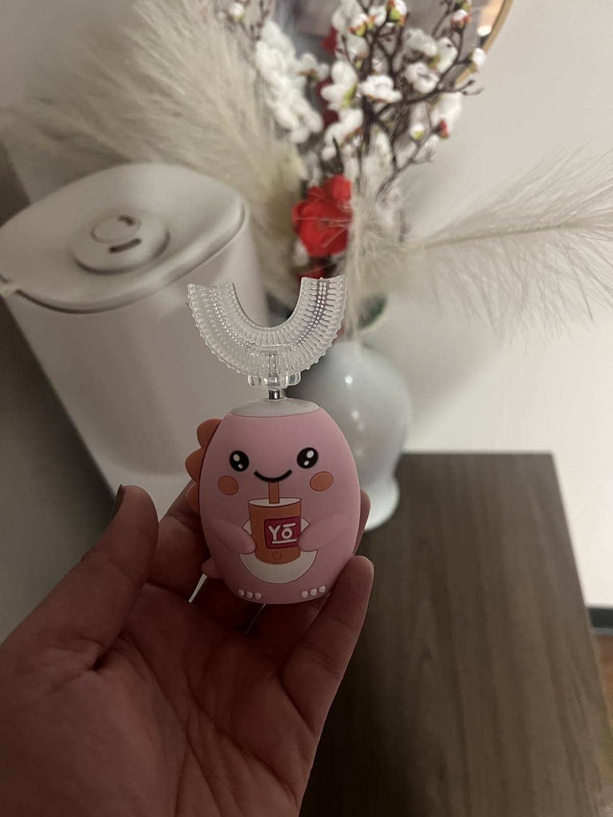 Parent holding the blush pink SnugBrush with the U-shaped head attached